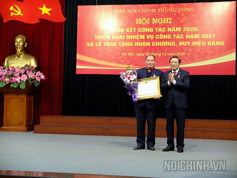 Đồng chí Phan Đình Trạc, Bí thư Trung ương Đảng, Trưởng Ban Nội chính Trung ương trao tặng Huân chương Lao động hạng Ba của Chủ tịch nước cho đồng chí Vũ Quốc Văn, hàm Vụ trưởng Vụ 4