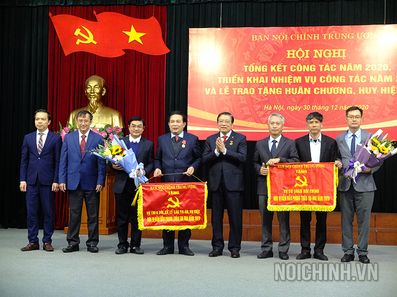Đồng chí Phan Đình Trạc, Bí thư Trung ương Đảng, Trưởng Ban Nội chính Trung ương trao Cờ Thi đua của Ban Nội chính Trung ương cho tập thể Vụ 1 và Vụ 4