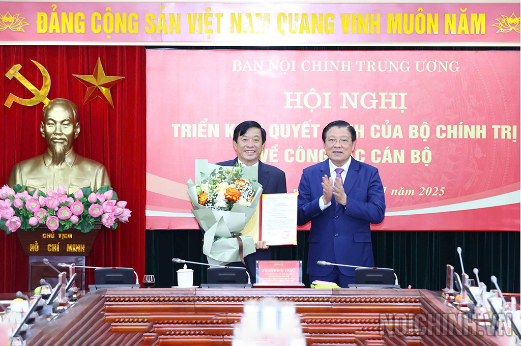 Đồng chí Phan Đình Trạc, Ủy viên Bộ Chính trị, Bí thư Trung ương Đảng, Trưởng Ban Nội chính Trung ương trao Quyết định và tặng hoa chúc mừng đồng chí Bùi Văn Nghiêm
