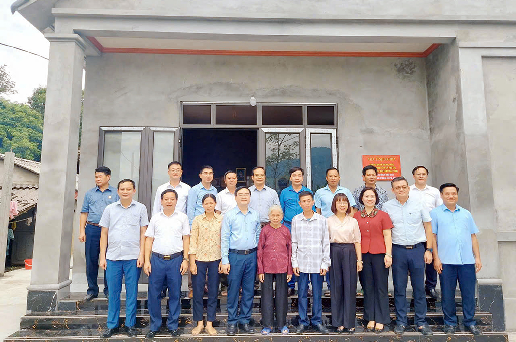 Các đại biểu Ban Nội chính Tỉnh ủy, Ngân hàng Nhà nước Khu vực 4, lãnh đạo xã Sơn Lương chụp ảnh lưu niệm cùng gia đình anh Nguyễn Huy Bằng